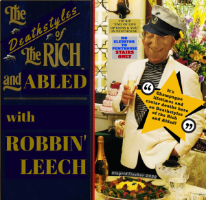 An old promotional graphic for the program, Lifestyles of the Rich and Famous With Robin Leach that’s been altered to read, Deathstyles of the Rich and Abled With Robbin’ Leech. Art: Gold logo of The Deathstyles of the Rich and Abled with Robbin’ Leech against a black background. To the right is a doctored photo of Robin Leach in what can only be described as a casual tuxedo look, and holding a glass of champagne next to a table with a bottle of bubbly and a bowl of caviar with a tiered cake in the background and a huge bunch of flowers. Layered on top of Robbin’s face is a cutout of Marty Feldman’s face and a separate cutout of a filthy captain’s hat on top. There are about six flies buzzing about the whole graphic. Text: Two signs are on the wall. The gold one reads VIP RIP “End-of-Life Options & You” in Penthouse. Right below that is a dingy sign reading, No Elevator To Penthouse Stairs Only. Layered on Robbin’ is a bright yellow star-shaped quote, “It’s Champagne lifetimes and caviar deaths here on Deathstyles of the Rich and Abled!”